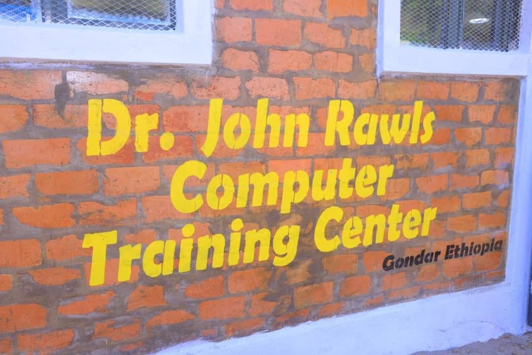 Painted exterior wall sign reading Dr. John Rawls Computer Training Center Gondar Ethiopia