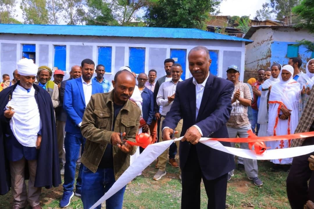 Community elders, officials, and organizers cutting the ceremonial ribbon during the training center opening